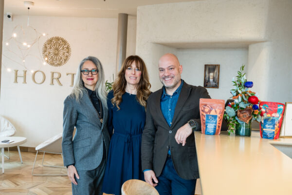 Tre persone sorridono, con confezioni di caffè 1895 Lavazza. Slow breakfast e rito del caffè.