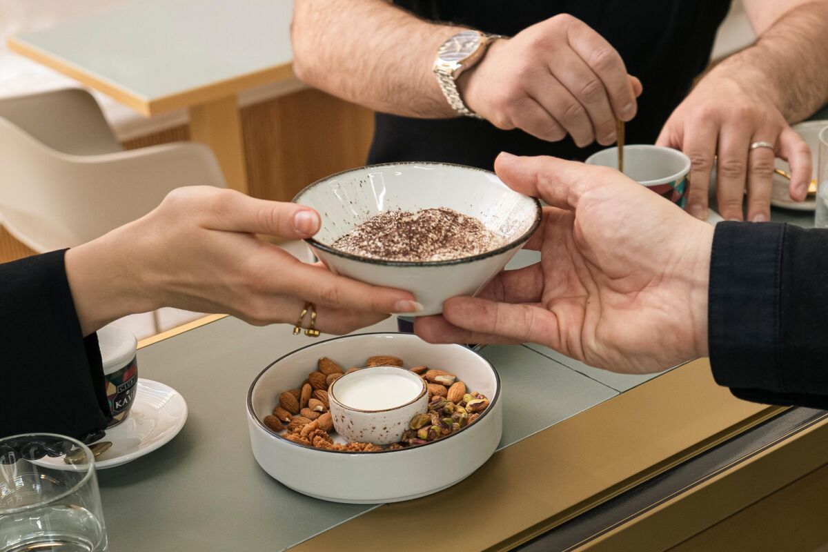 Pasticceria Tommaso Foglia Nola: mani offrono dessert. Cioccolato, frutta secca e caffè.