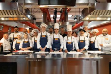 Team di cucina Le Stelle di Domani. Giovani chef italiani in posa con divise e cappelli da cuoco. Talento culinario.