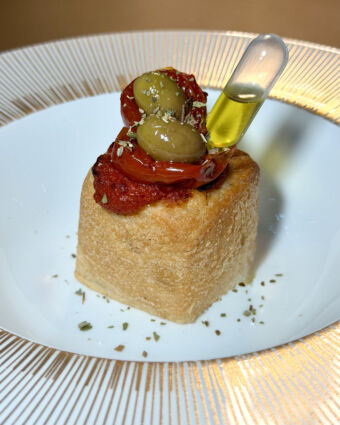 Cucina d'autore: pizza pugliese Altograno® con pomodori secchi, olive e olio extravergine.