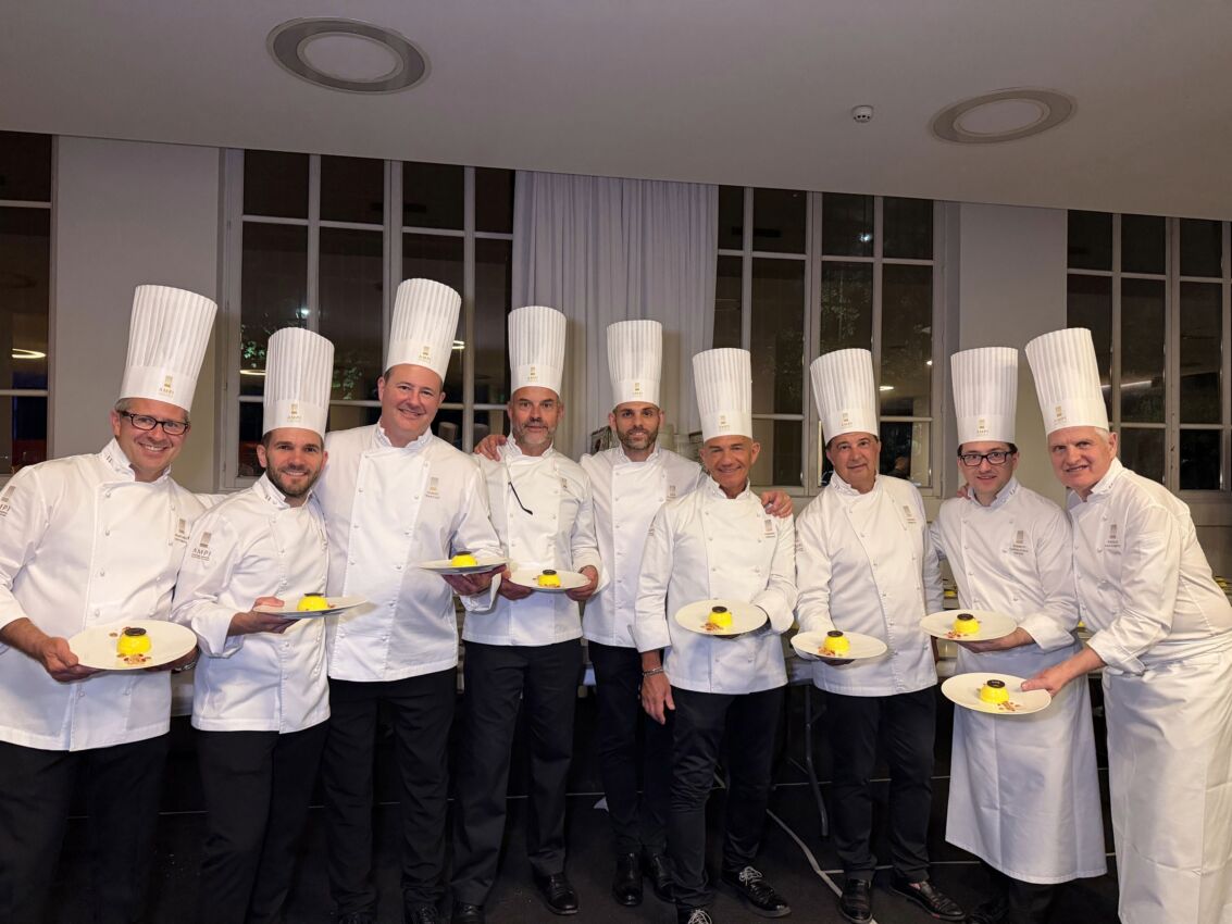 Gruppo di pasticceri AMPI in divisa presenta il dolce Lumen creato per la Fondazione Telethon durante un evento.