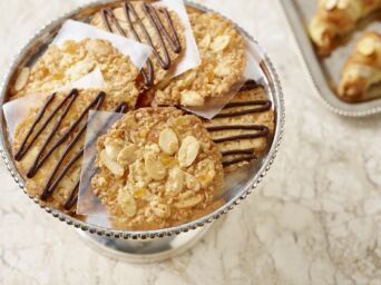 Biscotti croccanti alle mandorle della California con decorazione al cioccolato su un'alzata in metallo per bakery.