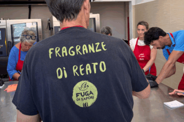 Pasticceria sociale Fuga di Sapori: pasticceri al lavoro con maglietta Fragranze di Reato nel laboratorio di bakery.
