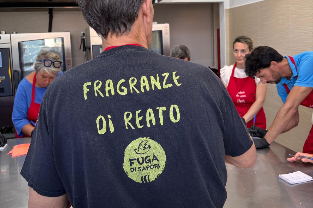 Pasticceria sociale Fuga di Sapori: pasticceri al lavoro con maglietta Fragranze di Reato nel laboratorio di bakery.