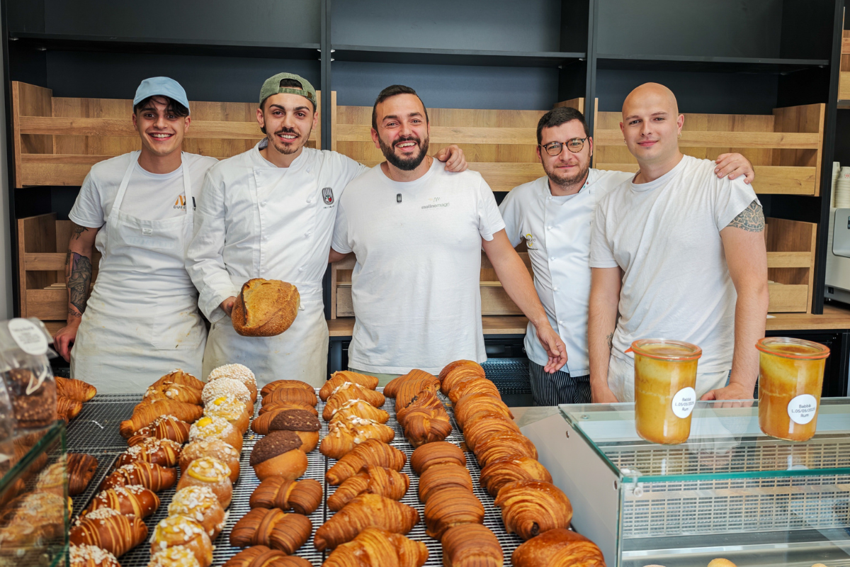Il team di Sfoorna, micro forno artigianale di Carpe Diem a Pescara, sorridente davanti a pane e cornetti appena sfornati.
