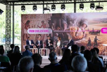 Panel di esperti al Lesaffre Symposium con sfondo storico sulla panificazione e il grano, pubblico in sala.