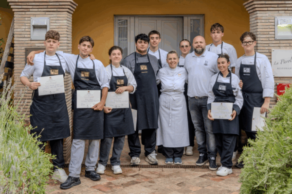 Giovani chef premiati al concorso culinario CombiGuru 2026 di Unox, in posa con attestati davanti al ristorante.