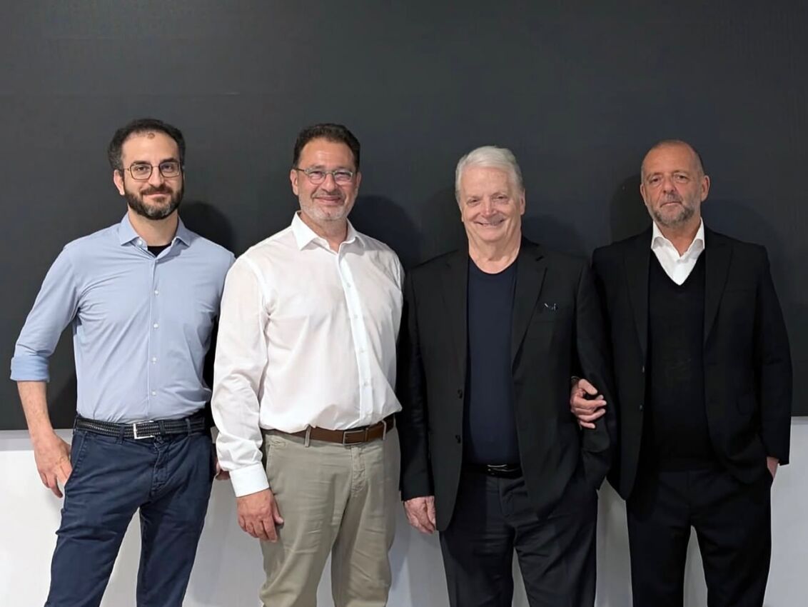 Nicola Massari, Sergio Castelli, Iginio Massari e Mario Esposito in posa insieme davanti a una parete scura.