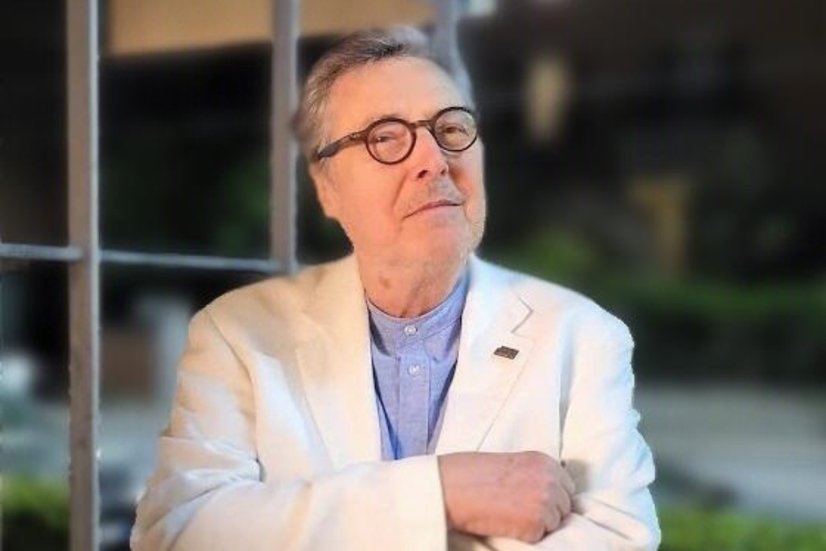 Ritratto di Gilberto Mora, figura storica della Compagnia del Cioccolato, in giacca bianca e occhiali.