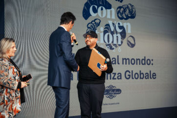 Antonio Bachour premiato sul palco dell'evento Le Sinfonie, con sfondo grafico dedicato alla pasticceria professionale.