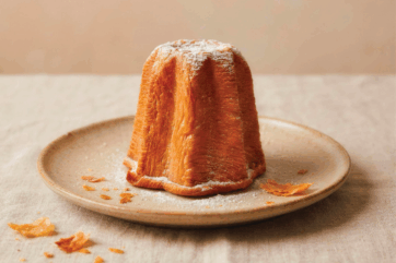 Sfogliato d'autore a lievitazione mista: un soffice panettone o pandoro artigianale spolverato di zucchero a velo.
