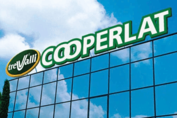 Insegne TreValli e Cooperlat su facciata in vetro, logo aziendale con cielo azzurro sullo sfondo