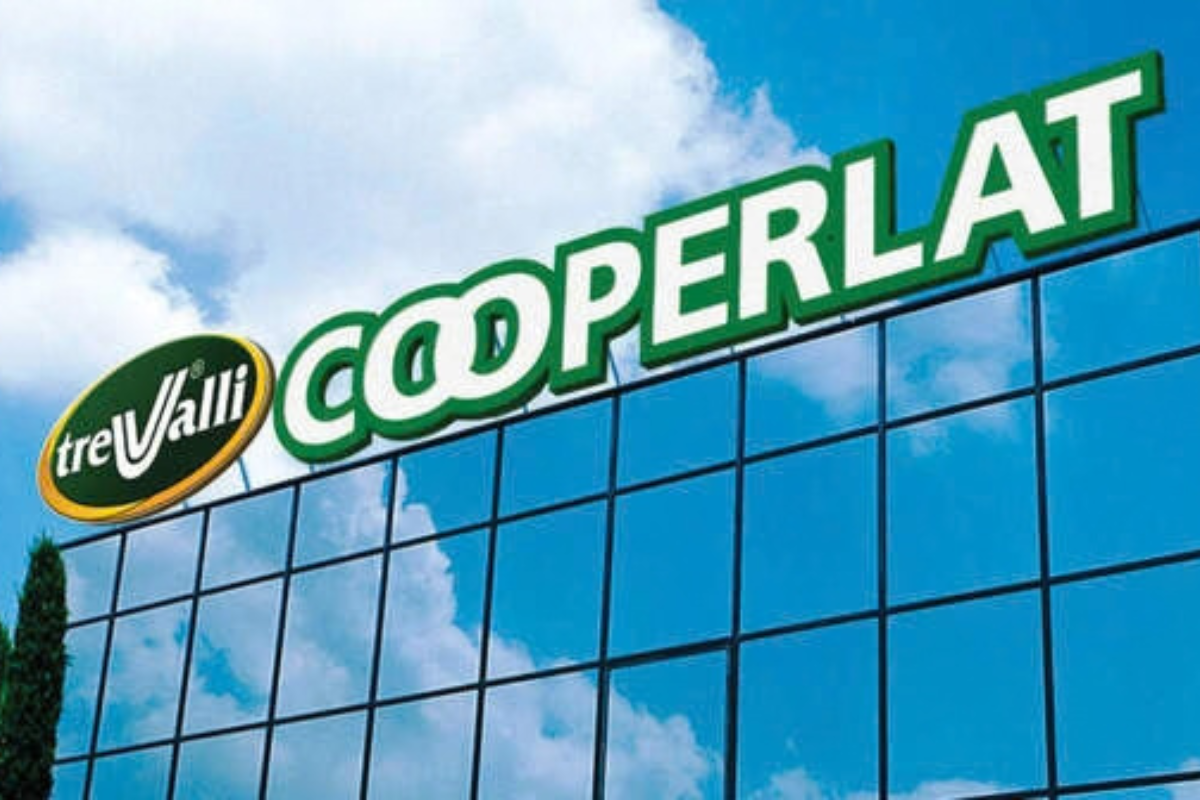 Insegne TreValli e Cooperlat su facciata in vetro, logo aziendale con cielo azzurro sullo sfondo