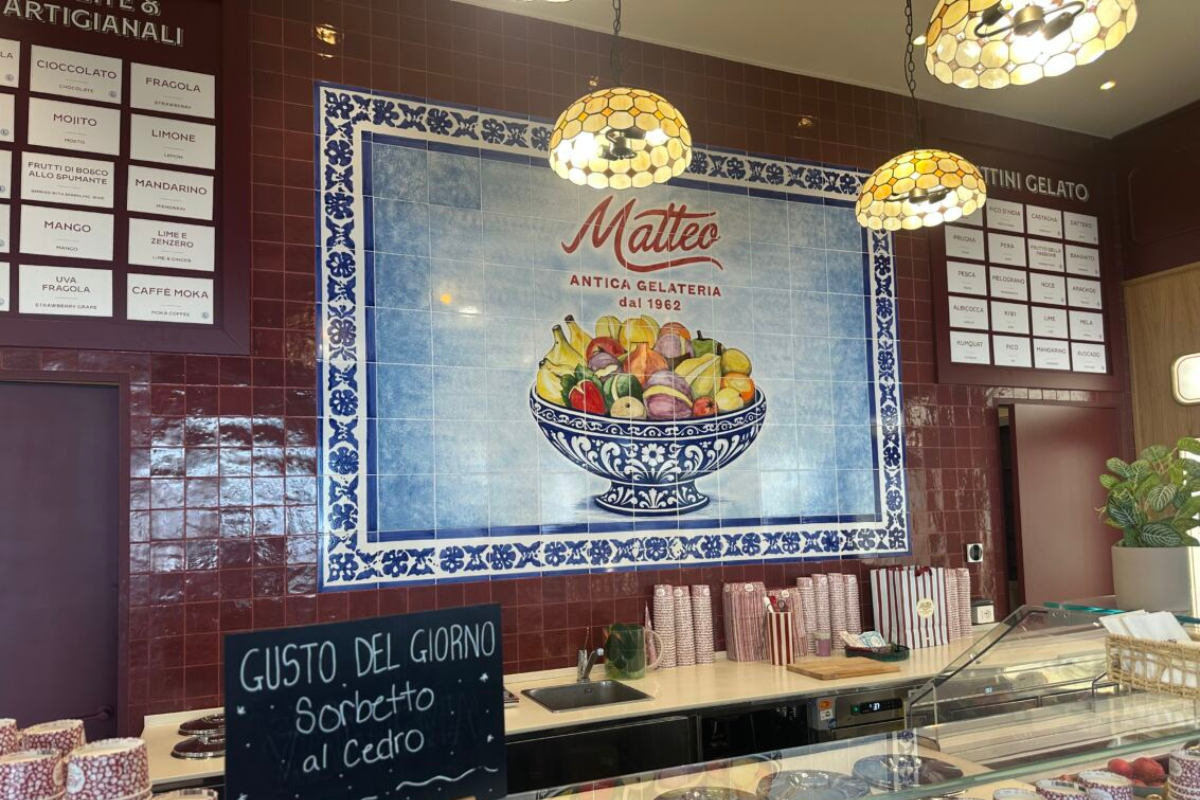 Interni di Antica Gelateria Matteo a Milano con decorazioni in ceramica, fruttini gelato e listino gusti artigianali.