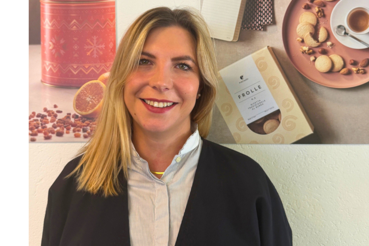 Anahi Pagura Pintaudi sorridente, nominata Amministratore Delegato, ritratta davanti a un'esposizione di prodotti.