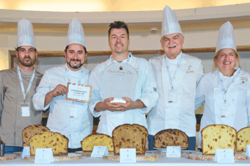 Pastry chefs con trofeo al Panettone Day 2026, concorso che premia il miglior panettone artigianale dolce e salato.