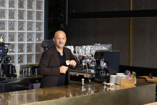 Francesco Sanapo, fondatore di Ditta Artigianale, al bancone del nuovo caffè di Via Capelli a Milano con tazzina in mano.