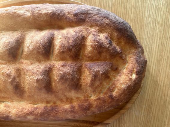 Pane armeno Matnakash, patrimonio Unesco, con crosta dorata e scanalature, su tagliere di legno