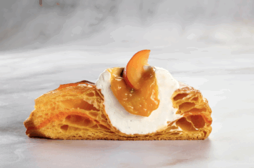 Pasta croissant Dulcis in Salis con crema e pesca su superficie marmorizzata