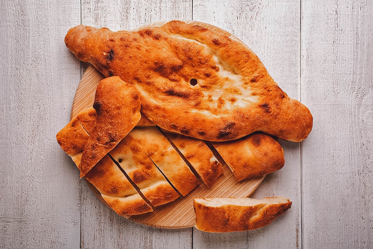 Shoti, il tradizionale pane armeno Patrimonio Unesco, servito a fette su tagliere di legno.