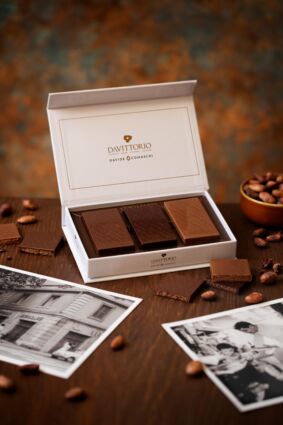 Confezione regalo tavolette cioccolato farcite Da Vittorio e Davide Comaschi su tavolo con foto storiche