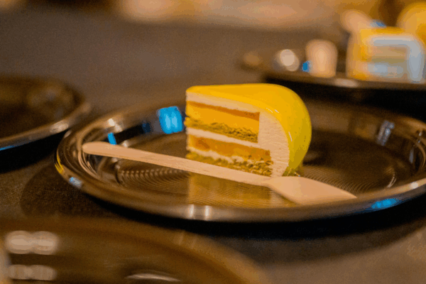 Dessert Couture di Giuseppe Manilia: fetta di dolce giallo glassato su piatto in passerella