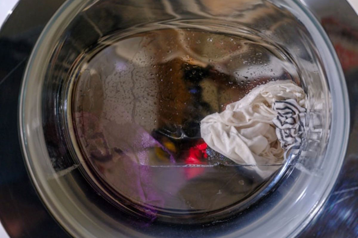 Interno lavatrice AEG con bucato. Cura dei tessuti e speed laundering per allungare la vita dei vestiti.