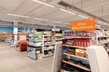 Interno negozio Action Milano. Scaffali con prodotti in offerta, illuminazione a neon. Nuovo store Action.