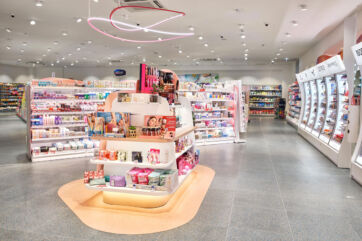 Interni del nuovo store dm a Bolzano. Scaffali con prodotti di bellezza e cura personale. Illuminazione moderna.