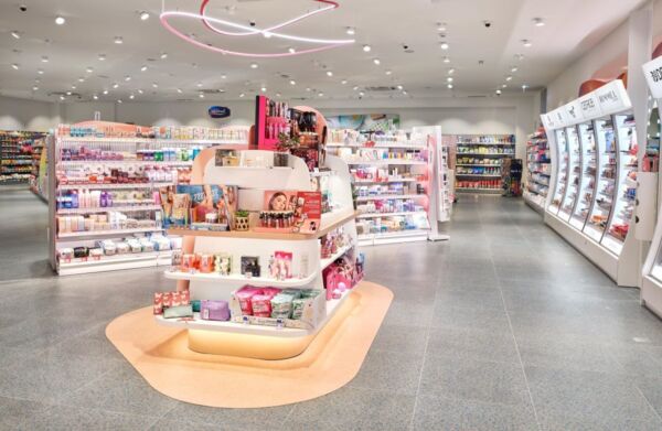 Interni DM: scaffali cosmetici, illuminazione neon rosa. Prodotti bellezza, cura personale. Design moderno, luminoso.