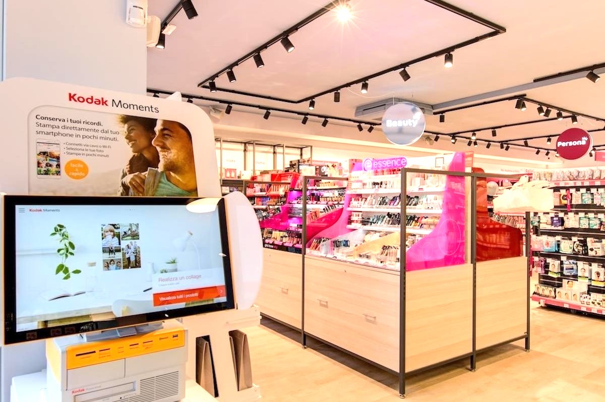 Conad PiùMe: interno negozio con prodotti beauty e stampa foto Kodak Moments.