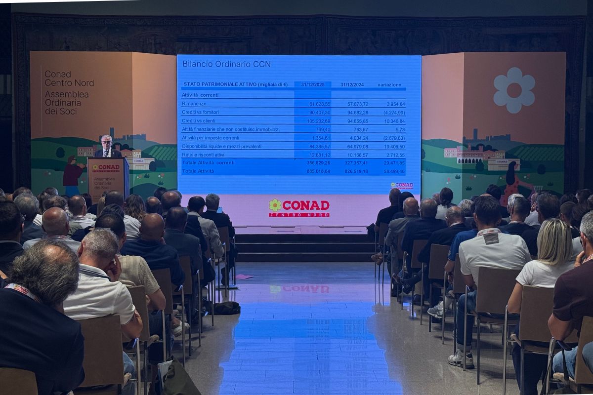 Assemblea dei soci Conad Centro Nord: presentazione bilancio 2025 con dati finanziari su schermo e platea in sala.