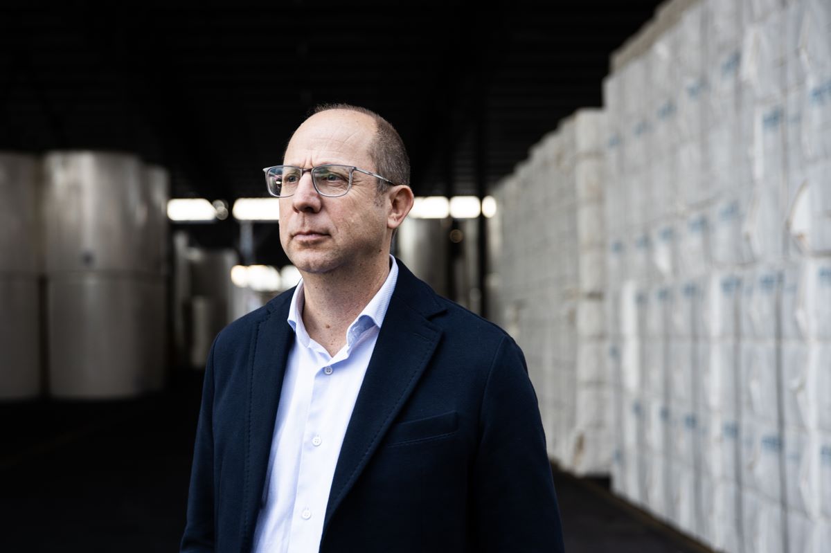 Riccardo Balducci di Sofidel in un magazzino, impegnato nella strategia di sostenibilità e lotta al cambiamento climatico.