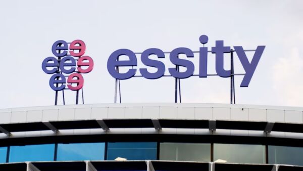 Insegna aziendale con logo e scritta blu Essity posizionata sul tetto di un moderno edificio per uffici.