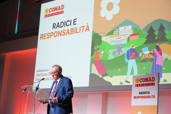 Conad Adriatico, incontro su cooperazione e cambiamento: relatore sul palco e slide Radici e Responsabilità