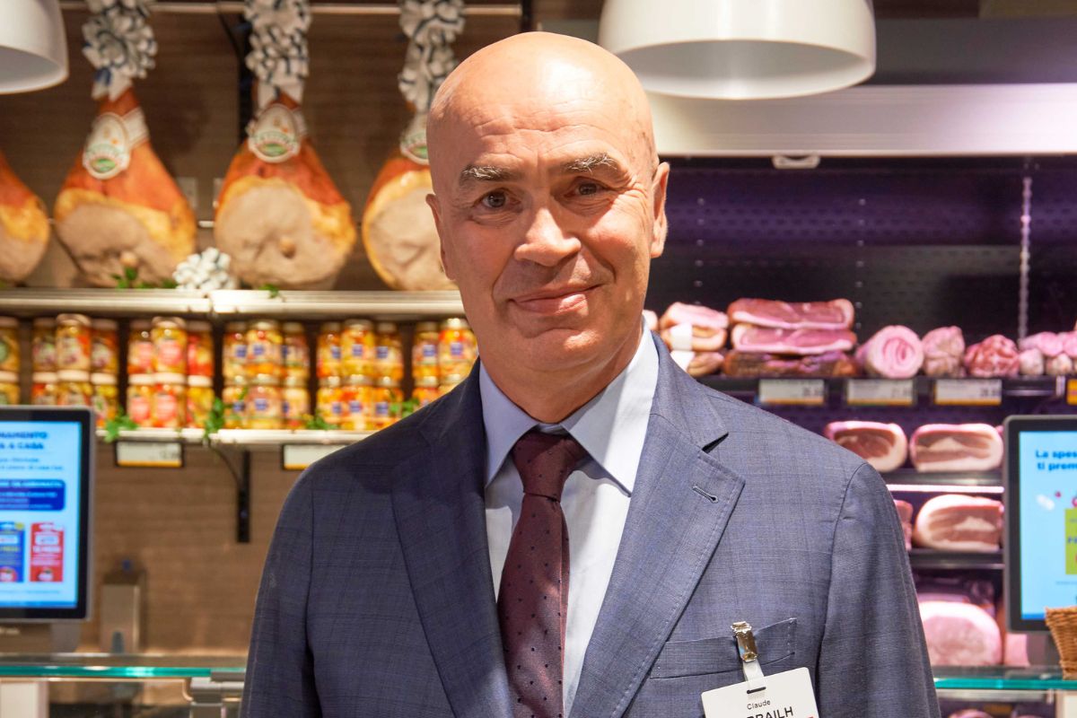 Claude Sarrailh, nuovo Ceo di Esselunga, in abito elegante nel reparto gastronomia di un supermercato