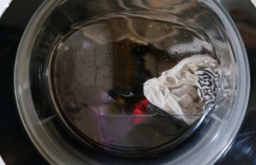 Vaso di vetro con acqua sporca e straccio bianco: metafora del diritto alla riparazione e delle nuove regole post-vendita.