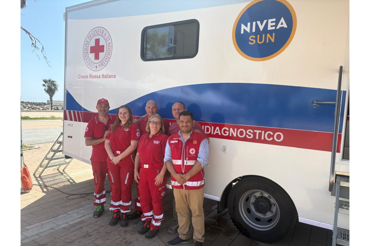 Team Croce Rossa Italiana con unità mobile Nivea Sun per diagnosi e prevenzione.