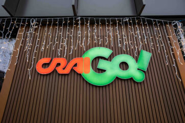 Insegna CraiGo! Milano: logo arancione e verde su parete in legno. Inaugurazione nuovo Hubquarter Crai.