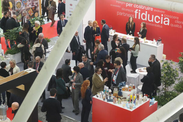Fiera Marca 2026: stand affollato con prodotti non food e alimentari. Persone in visita, atmosfera vivace.