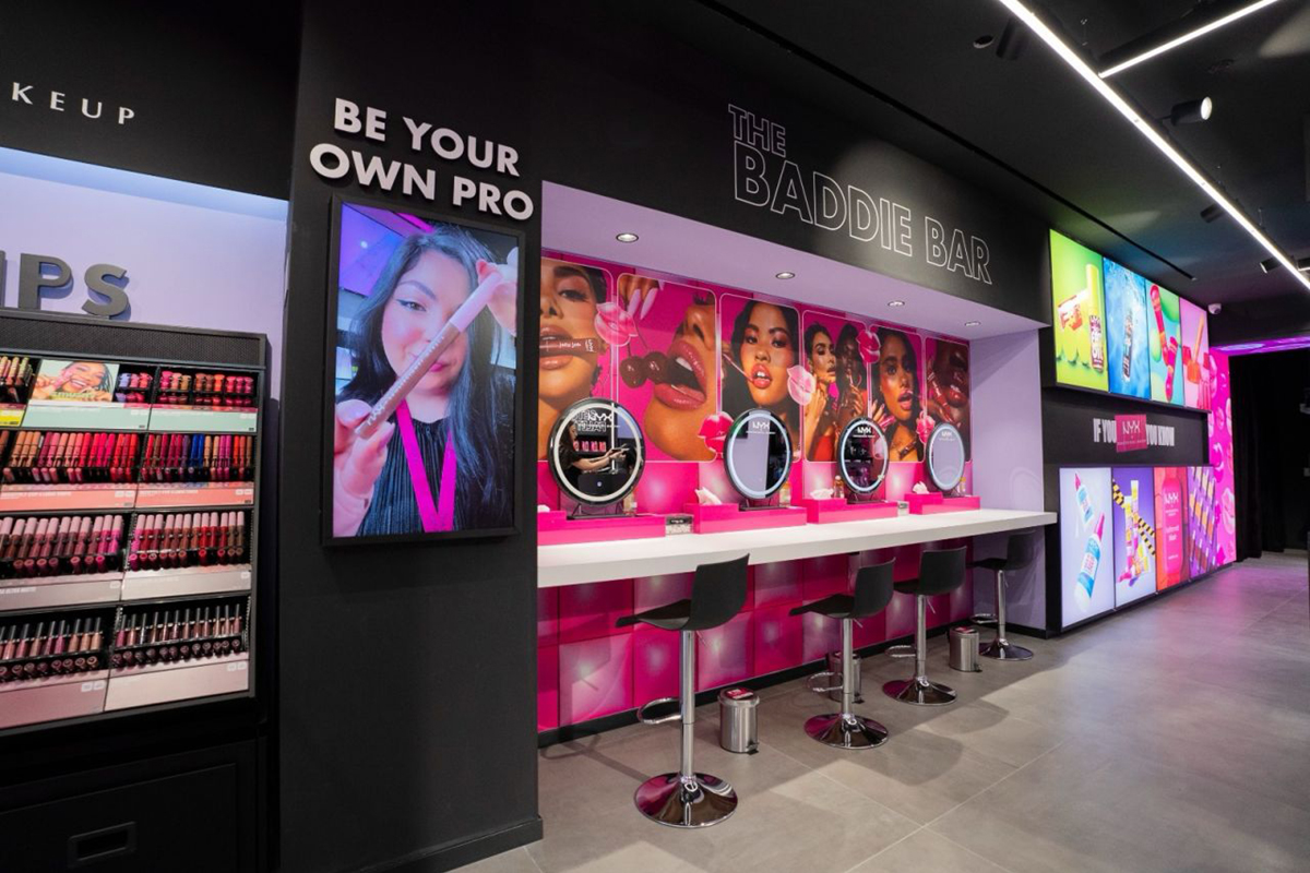 Negozio NYX Professional Makeup Milano: espositori make-up, postazioni trucco The Baddie Bar, colori vivaci.
