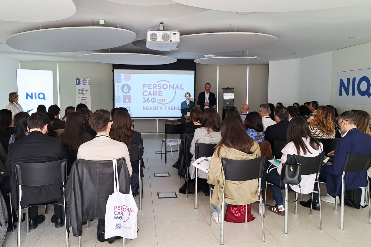 Conferenza sui beauty trend: pubblico attento, relatori sul palco. Focus su consumatori, canali e fedeltà.