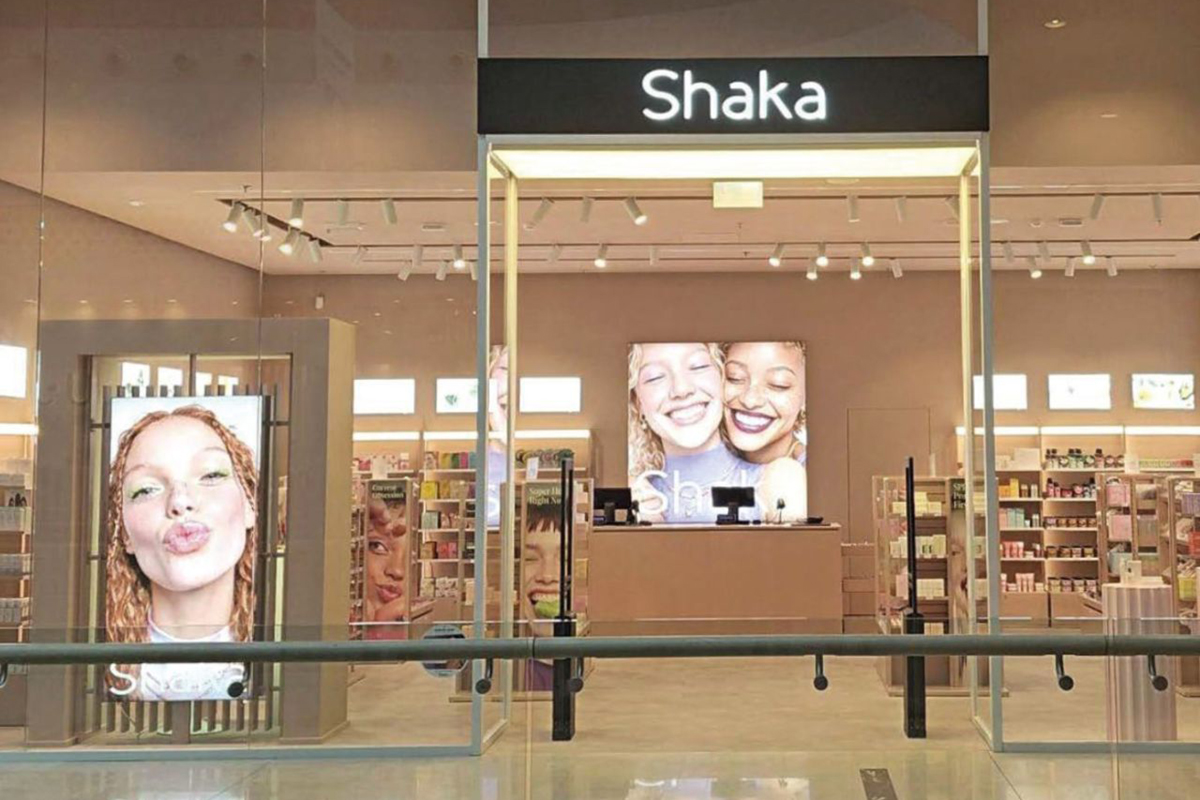 Negozio Shaka Beauty da OVS: prodotti make-up e cosmetici. Vetrine con immagini di donne sorridenti.