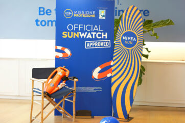 Nivea Sun e AIRC: protezione solare. Stand con salvagente, sedia da regista e tavola da surf. Prevenzione tumori della pelle.