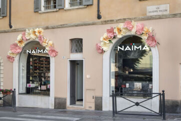 Vetrina Naima Brescia: profumeria con decorazioni floreali. Shopping di bellezza e fragranze.