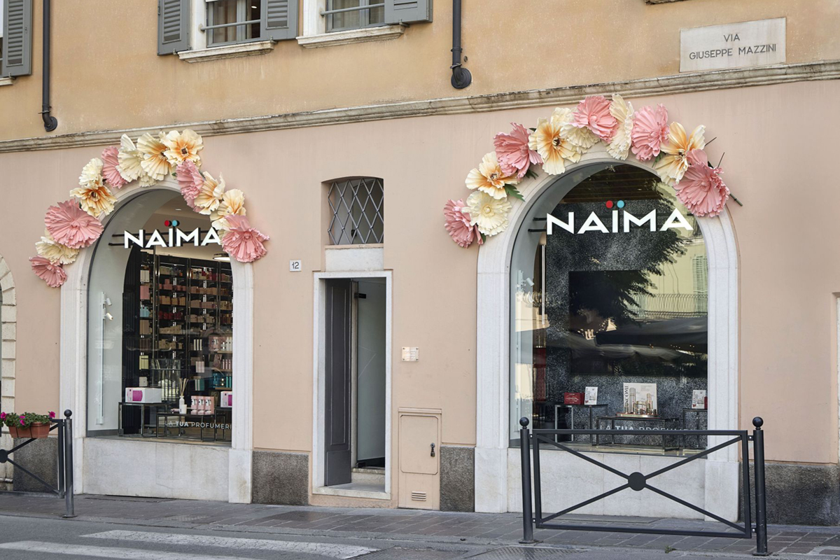 Vetrina Naima Brescia: profumeria con decorazioni floreali. Shopping di bellezza e fragranze.