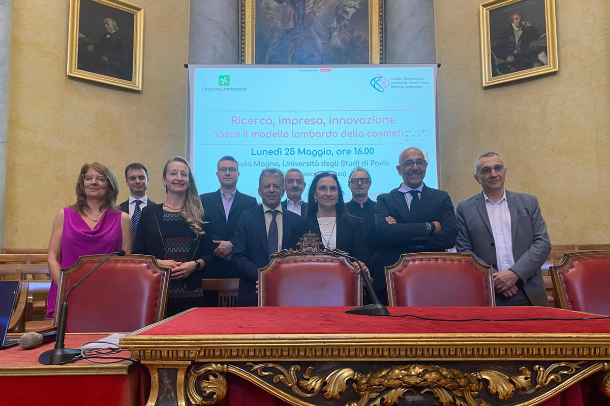 Gruppo di relatori al convegno sul Cluster Cosmetico Lombardo presso l'Università di Pavia, evento su ricerca e innovazione.