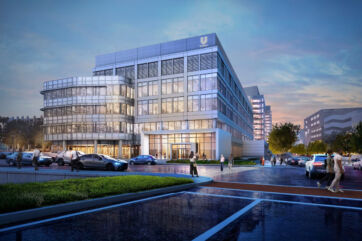 Nuovo hub Unilever a New Haven, USA: edificio moderno in vetro con uffici, parcheggio e persone all'ingresso al tramonto.