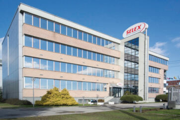 Sede del Gruppo Selex a Trezzano sul Naviglio, edificio moderno con ampie vetrate e logo aziendale sul tetto.