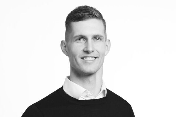 Ritratto in bianco e nero di Jesper Brask Laumann, Country Manager di Normal Italia, sorridente su sfondo neutro.